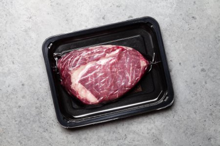 Foto de Vacuum packed beef steak. Raw ribeye steak. Top view flat lay - Imagen libre de derechos