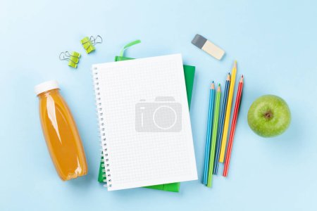 Téléchargez les photos : Blank notepad, juice bottle, apple and colorful pencils. Flat lay over blue background with copy space - en image libre de droit