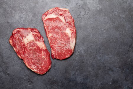 Téléchargez les photos : Deux steaks crus de bœuf. Vue du dessus plat avec espace de copie - en image libre de droit
