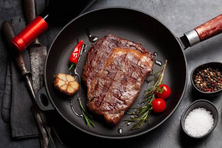 Téléchargez les photos : Steak de bœuf côtelé grillé dans une poêle avec des herbes et des épices. Pose plate - en image libre de droit