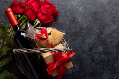 Téléchargez les photos : Carte Saint-Valentin avec bouteille de vin, biscuits en forme de coeur, fleurs roses et espace pour vos salutations - en image libre de droit