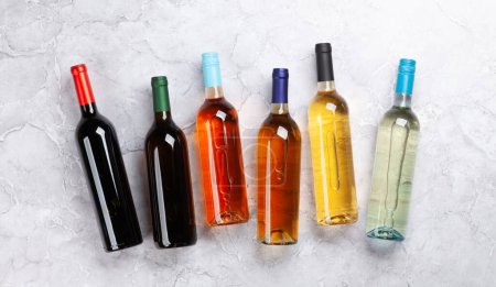 Foto de Varias botellas de vino en la mesa de piedra. Puesta plana - Imagen libre de derechos