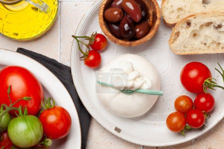Téléchargez les photos : Fromage burrata, tomates et olives variées. Cuisine italienne. Pose plate - en image libre de droit