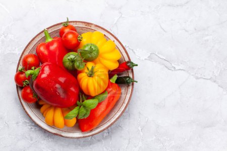 Foto de Various colorful garden tomatoes and bell peppers. Fresh vegetables. Top view flat lay with copy space - Imagen libre de derechos