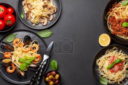 Téléchargez les photos : Différentes pâtes italiennes. Fruits de mer, champignons et sauce tomate pâtes, spaghettis bolognaise. Vue du dessus plat avec espace de copie - en image libre de droit