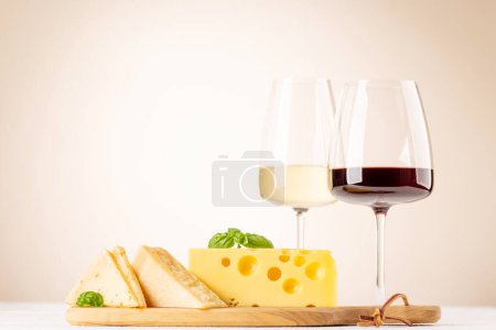 Foto de Various cheese on board and wine. Over beige background with copy space - Imagen libre de derechos