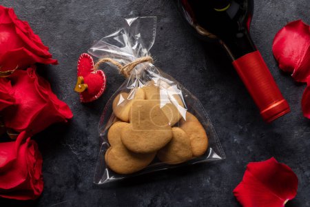 Téléchargez les photos : Valentines day card with wine bottle, heart shaped cookies, rose flowers - en image libre de droit