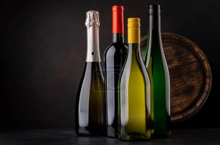 Téléchargez les photos : White and red wine bottles, champagne in front of wine barrel with copy space - en image libre de droit