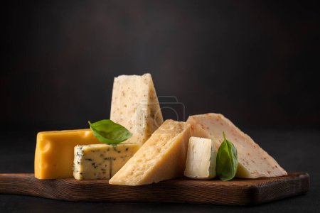 Foto de Various cheese on board on stone table - Imagen libre de derechos