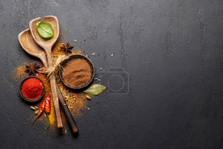 Photo for Various spices in bowls and spoons on stone table. With copy space for your menu or recipe - Royalty Free Image