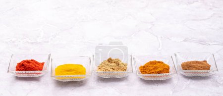 Foto de Various dried spices in small bowls on stone table with copy space - Imagen libre de derechos