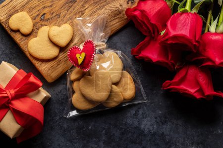 Foto de Tarjeta de San Valentín con galletas en forma de corazón, flores de rosas y caja de regalo. Puesta plana - Imagen libre de derechos