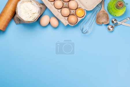 Téléchargez les photos : Ingrédients et ustensiles de cuisine sur fond bleu. Pose plate avec espace de copie - en image libre de droit