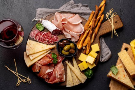 Foto de Antipasto board with various meat and cheese snacks. Flat lay - Imagen libre de derechos