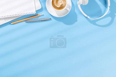 Foto de Escritorio de oficina de vista superior con computadora portátil, suministros de oficina y café. Espacio de trabajo con luz soleada y espacio de copia - Imagen libre de derechos