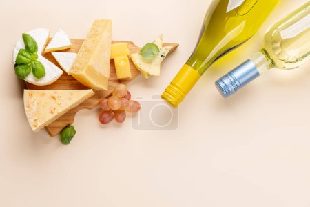 Téléchargez les photos : Various cheese on board and white wine. Flat lay with copy space - en image libre de droit