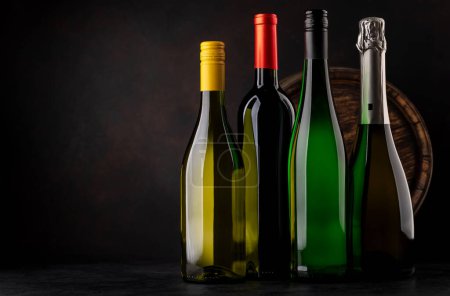 Téléchargez les photos : White and red wine, champagne bottles in front of wine barrel - en image libre de droit