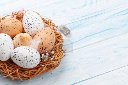 Téléchargez les photos : Easter greeting card with easter eggs in nest. With copy space - en image libre de droit