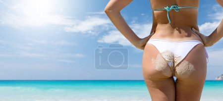 Photo for Back of beautiful girl in bikini with sand on the sea beach. Enjoy and relax in summer with copy space - Royalty Free Image
