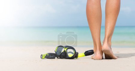 Téléchargez les photos : Snorkeling mask on sand beach and woman legs. Summer travel vacation - en image libre de droit