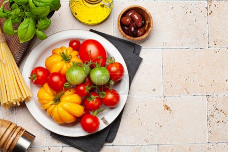 Téléchargez les photos : Diverses tomates de jardin colorées. Légumes frais et épices. Vue du dessus plat avec espace de copie - en image libre de droit