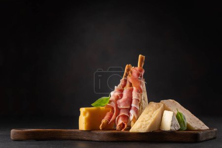 Photo for Antipasto board with various cheese and prosciutto snacks - Royalty Free Image
