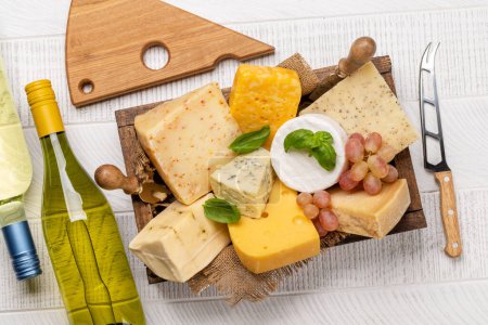 Téléchargez les photos : Various cheese on board and white wine. Flat lay - en image libre de droit