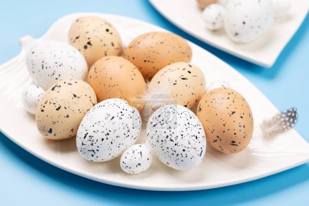 Téléchargez les photos : Easter eggs on plate over a blue background - en image libre de droit
