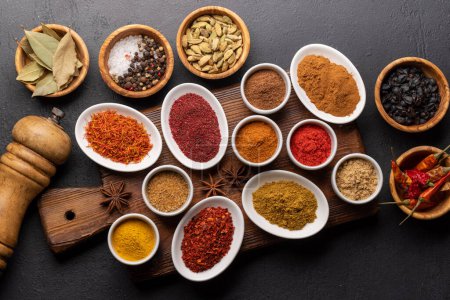 Photo for Various dried spices in small bowls on wooden board - Royalty Free Image