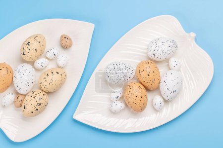Foto de Huevos de Pascua en plato sobre fondo azul. Pollo y huevos de codorniz. Puesta plana - Imagen libre de derechos