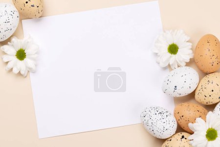 Foto de Easter eggs and flowers on a beige background with space for your greetings. Flat lay - Imagen libre de derechos