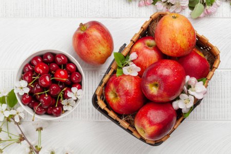 Photo for Ripe red apples and cherry on wooden table. Top view flat lay - Royalty Free Image