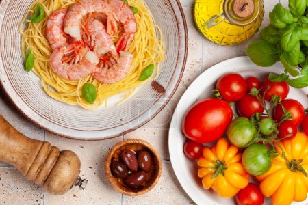 Foto de Pasta con gambas y varios tomates de jardín. Cocina italiana. Puesta plana - Imagen libre de derechos