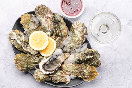 Photo for Fresh oysters with sauce and lemons. With glass of sparkling wine. Flat lay - Royalty Free Image