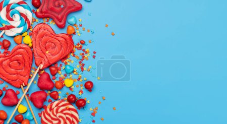 Photo for Various candy sweets on blue background and copy space for your text. Flat lay - Royalty Free Image