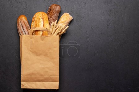Photo for Fresh baked bread on stone table. Flat lay with copy space - Royalty Free Image