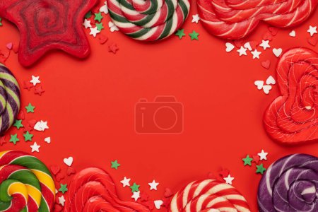 Photo for Various candy sweets and lollipops on red background and copy space for your text. Flat lay - Royalty Free Image