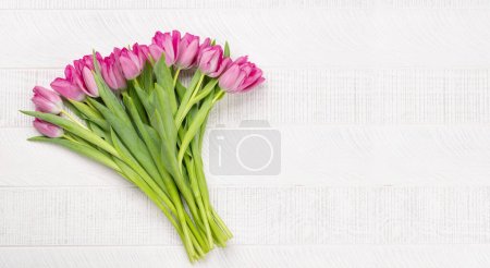 Téléchargez les photos : Pink tulip flowers bouquet on white wooden table. Flat lay with copy space - en image libre de droit