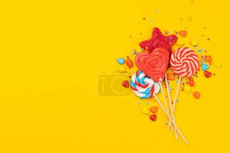 Photo for Various candy sweets and lollipops on yellow background and copy space for your text. Flat lay - Royalty Free Image