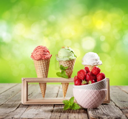 Téléchargez les photos : Différentes glaces dans des cônes de gaufres. Fraise, pistache et glace à la vanille. Avec espace de copie - en image libre de droit