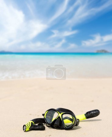 Foto de Máscara de snorkel en la playa de arena frente al soleado paisaje marino. Vacaciones de verano - Imagen libre de derechos