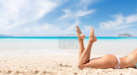 Téléchargez les photos : Woman lying on the sea beach enjoying and relaxing in summer. With copy space - en image libre de droit