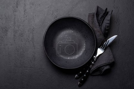 Téléchargez les photos : Assiette vide avec fourchette et couteau sur table en pierre sombre. Pose plate avec espace de copie - en image libre de droit