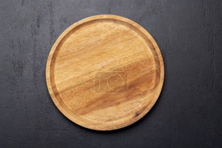Foto de Tabla de cortar de madera en la mesa de la cocina de piedra. Piso con espacio de copia - Imagen libre de derechos