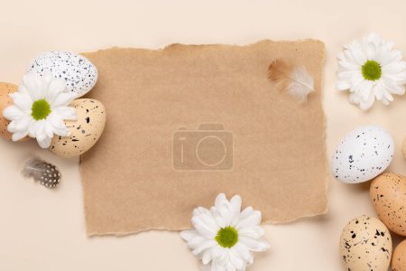 Foto de Easter eggs and flowers on a beige background with space for your greetings. Flat lay - Imagen libre de derechos