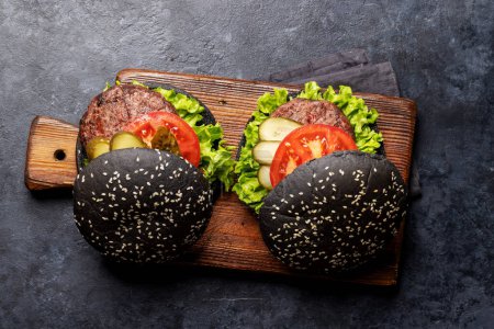 Photo for Homemade beef burgers with black buns. Flat lay - Royalty Free Image