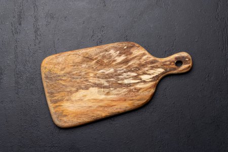 Téléchargez les photos : Planche à découper en bois sur table de cuisine en pierre. Pose plate avec espace de copie - en image libre de droit