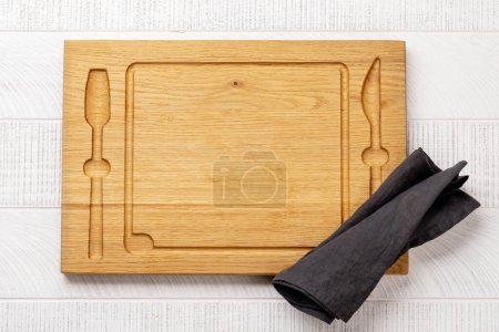Téléchargez les photos : Wooden cutting board and kitchen towel. Flat lay with copy space - en image libre de droit