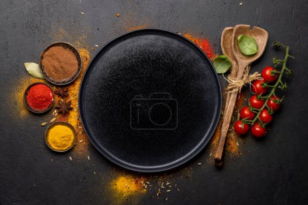 Téléchargez les photos : Empty plate and various spices on stone table. Frame with copy space for your menu or recipe - en image libre de droit