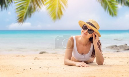 Foto de Mujer tumbada en la playa del mar disfrutando y relajándose en verano - Imagen libre de derechos